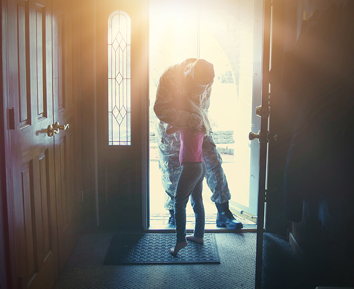 Military dad returns home and embraces daughter in doorway