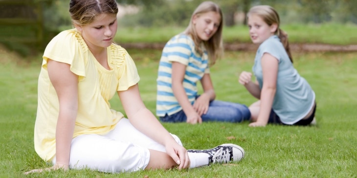 Niñas acosando a otra niña al aire libre