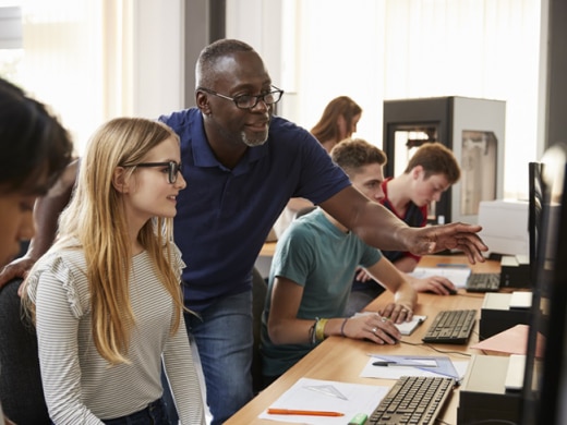 Teacher points something to student on monitor