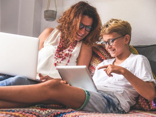 Child and mommy communicate and plays with tech device.