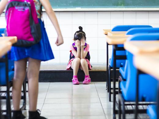 Little girl bullying in school classroom.