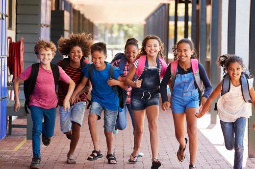 책가방을 메고 웃으면서 함께 학교 복도를 달리는 중학생 그룹.